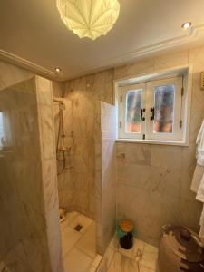 a bathroom with a shower and a window and a chandelier at Casa Blanca Old City - Alkmaar in Alkmaar