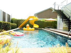 Una piscina con un tobogán y un fideo de piscina en un patio trasero. en Thacha Pool Villa A, en Hua Hin 8 fotos más