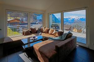 a living room with a couch and a large window at Modern and cosy 5 rooms penthouse with stunning view in Triesenberg