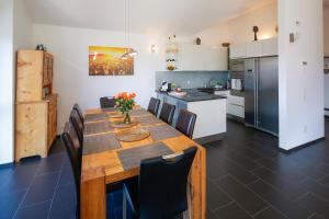 a kitchen with a wooden table and chairs in a room at Modern and cosy 5 rooms penthouse with stunning view in Triesenberg