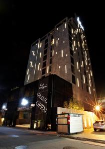 un gran edificio con un cartel en él por la noche en Lee Design Hotel, en Yongin