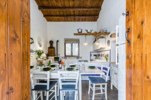 a kitchen with a large white table and chairs at Authentic Sicilian Charm, pool, sea view, wi-fi & parking in Avola