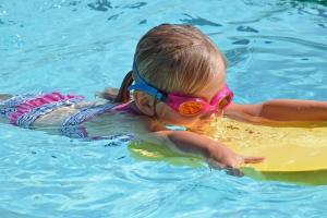 a little girl in a swimming pool wearing goggles at Campanula 52- Sint Maartenszee in Sint Maartensvlotbrug