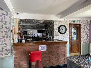 a kitchen with a counter and a clock on the wall at The Unicorn Hotel in Caersws