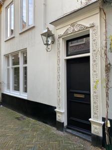 a building with a black door and a street at Casa Blanca Old City - Alkmaar in Alkmaar