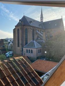 een grote kerk met een groot gebouw met een toren bij Casa Blanca Old City - Alkmaar in Alkmaar