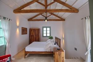 a bedroom with a bed and a wooden ceiling at Villa Aquilo in Megali Ammos