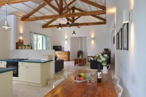 eine Küche und ein Wohnzimmer mit einem Holztisch in der Unterkunft Villa Aquilo in Megali Ammos