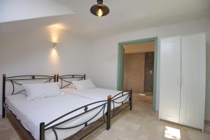 a bedroom with a bed with white sheets at Villa Aquilo in Megali Ammos