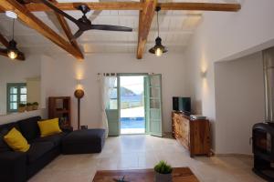 ein Wohnzimmer mit einem Sofa und einem TV in der Unterkunft Villa Aquilo in Megali Ammos