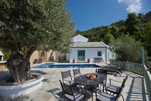 a patio with a table and chairs next to a pool at Villa Aquilo in Megali Ammos