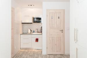 a kitchen with white cabinets and a door at HeroHostel in Sieradz +28 photos