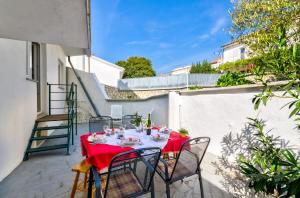 een tafel met een rood tafelkleed op een terras bij DADA in Novi Vinodolski
