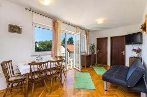 een woonkamer met een tafel, stoelen en een bank bij DADA in Novi Vinodolski