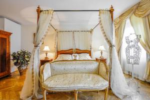 a bedroom with a canopy bed and a chair at Hotel Residence Green Lobster in Prague