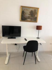 un escritorio blanco con monitor y silla en Resitur Apto 731, en Sevilla