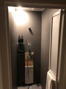 a bathroom with a shower and a light on the wall at ZONK HOTEL Haruyoshi-Teramachidori in Fukuoka