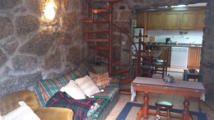 a living room with a couch and a stone wall at Casa do Faroca in Vieira do Minho