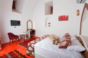 ein Wohnzimmer mit einem weißen Sofa und einem TV in der Unterkunft BEHRAMPAŞA OTEL &CAFE &RESTAURANT in Sivas