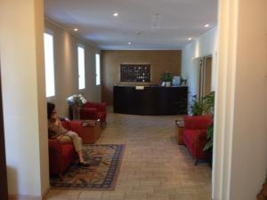 a woman sitting in a chair in a lobby at Hotel Terme Belvedere in Abano Terme