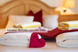 a red heart sitting on top of a bed at Gasthof Skirast in Kirchberg in Tirol