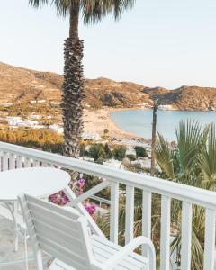 a beach scene with a balcony overlooking the ocean at Far Out Hotel & Spa in Mylopotas