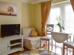 a living room with a tv and a couch at 1-Bed Cottage on Coastal Pathway in South Wales in Gileston