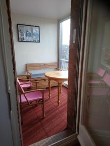 Zimmer mit einem Tisch, Stühlen und einem Fenster in der Unterkunft OPALINE T3 lumineux avec patio et parking privé in Dunkerque