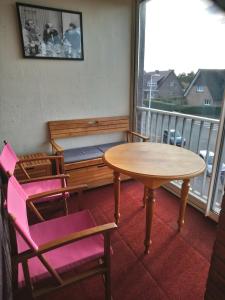 een kamer met een tafel en stoelen en een balkon bij OPALINE T3 lumineux avec patio et parking privé in Duinkerke