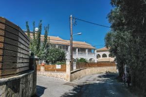 a fence in front of a house with a building at Lea Family Resort in Kassiopi