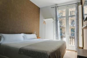 Postel nebo postele na pokoji v ubytování Cosmopolitan Boutique Rambla