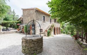 a stone building with a fountain in front of it at Casale Gli Angeli-Charming Villa with Garden and Parking! in Gubbio