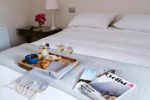 a tray of food and drinks on a bed at The Apple Rooms - Houghton Lodge in Stockbridge +46 photos