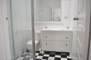 a white toilet sitting next to a shower in a bathroom at Fremantle Colonial Home in Fremantle
