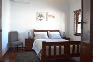 a bedroom with a bed and a chair at Fremantle Colonial Home in Fremantle
