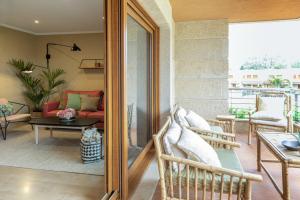 patio z krzesłami i stołem na balkonie w obiekcie P18 Villalia Apartamento en la Isla de la Toja w mieście Isla de la Toja