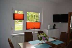 a dining room with a table and two windows at Ferienhaus Hüthchen in Eichhorst