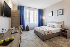 a hotel room with a bed and a television at Prestige Boutique Hotel Craiova in Craiova