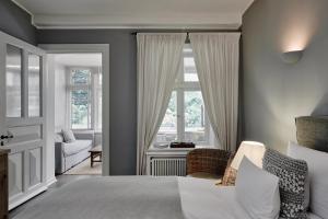 ein Schlafzimmer mit einem Bett, einem Stuhl und einem Fenster in der Unterkunft Landhaus Flottbek Boutique Hotel in Hamburg