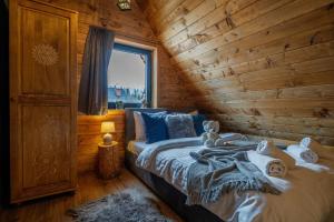 a bedroom with a bed in a log cabin at Szałas "Jodłowe Izby" in Białka Tatrzanska
