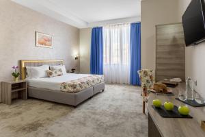 Una habitación de hotel con una cama y un escritorio con un escritorio en Prestige Boutique Hotel Craiova, en Craiova