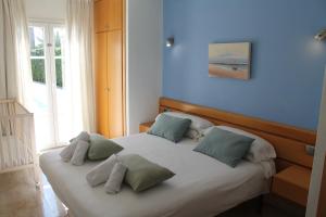 a bedroom with a bed with four pillows on it at Villa BETTY in Cala en Blanes +8 photos