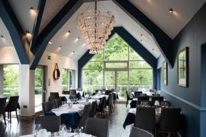 ein Esszimmer mit Tischen und Stühlen und einem Kronleuchter in der Unterkunft Exclusive 5 Bed Family House in Village Location in Sheepy