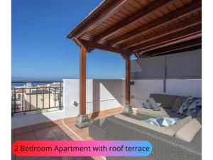 balcón con sofá y terraza en la azotea en Desirable Rooftop Terrace , 2 Bedroom apartment with WiFi by Aqua Vista Tenerife en Callao Salvaje