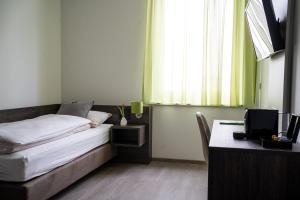 1 dormitorio con 1 cama y escritorio con ordenador en eee Hotel Graz en Neupirka