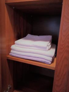 einen Stapel gefalteter Handtücher auf einem Regal in der Unterkunft Apartament Jonek in Krakau