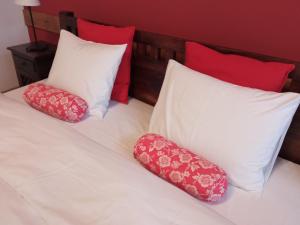 2 almohadas en una cama con almohadas rojas y blancas en Apartament Jonek, en Cracovia