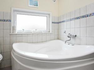 a white bath tub in a bathroom with a window at 10 person holiday home in Løkken-By Traum in Løkken +12 photos