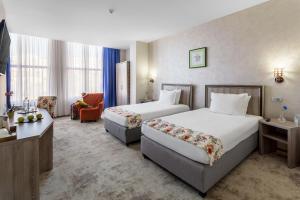 a hotel room with two beds and two lamps at Prestige Boutique Hotel Craiova in Craiova