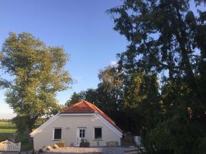 een klein wit huis met bomen op de achtergrond bij Ferienhaus Kaept n Poldi 25192 in Bunde